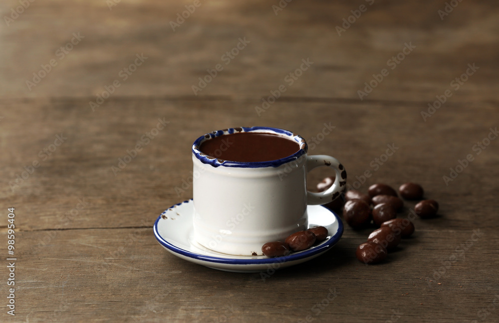 Cup of cacao with chocolate on wooden background
