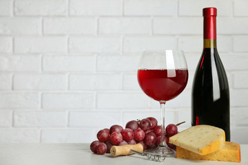 Canvas Print - Red wine with grape and cheese on brick wall background