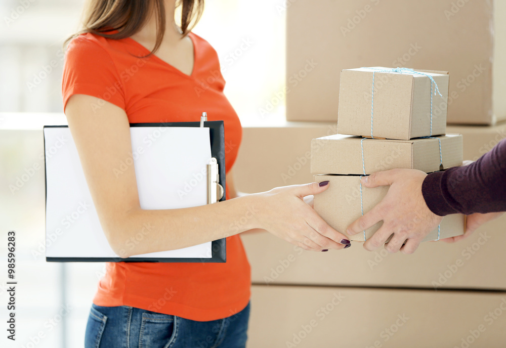 Young man receiving parcel from delivery worker, close up