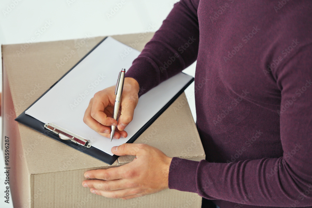 Man signing receipt of delivery package, close up