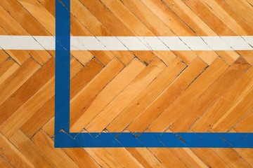 Blue white lines. Worn out wooden floor of sports hall with colorful marking lines.