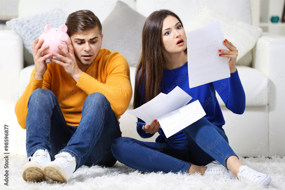 Happy couple in a room with money
