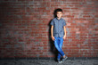 © Africa Studio - Cute little boy on brick wall background. Kids fashion concept