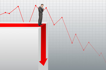 Sad businessman standing on edge of chart