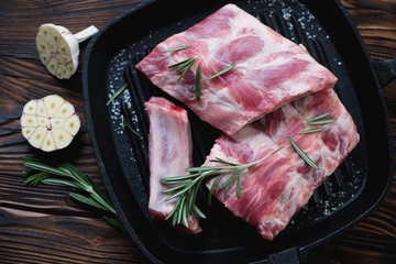 Wall Mural - Grill with raw pork ribs and seasonings, above view, close-up