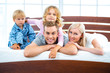 Young family lying on white bed
