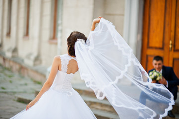 Bride play with veil  background her groom