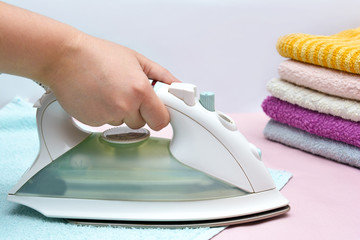 Iron in the woman hand. Ironing