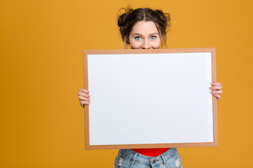 Sticker - Smiling cute lovely young woman hiding behind blank board