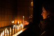 Young woman light a candle in a church in Istanbul ,Turkey