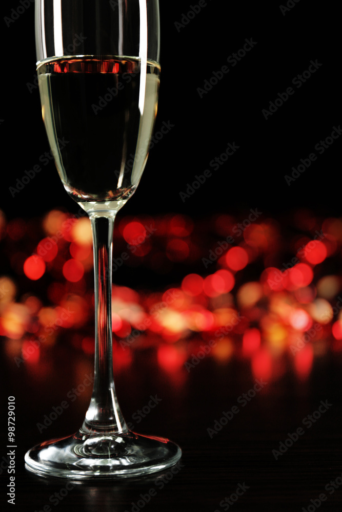 A glass of champagne with bokeh on dark background