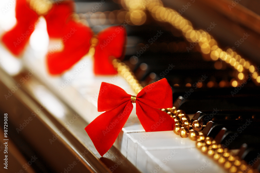 Piano keys decorated with golden Christmas decorations, close up