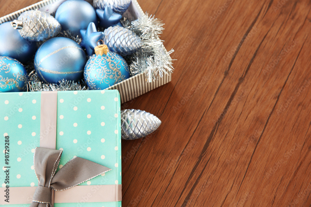 Box with Christmas toys on wooden background