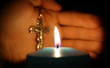 © MrP - burning candle on background of hands with cross