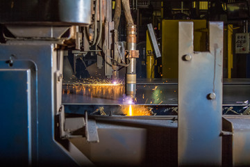 Wall Mural - 2 CNC Plasma torches cutting thin steel plate with orange sparks
