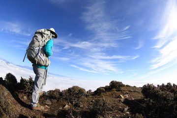 young woman backpacker hiking at beautiful mountain peak