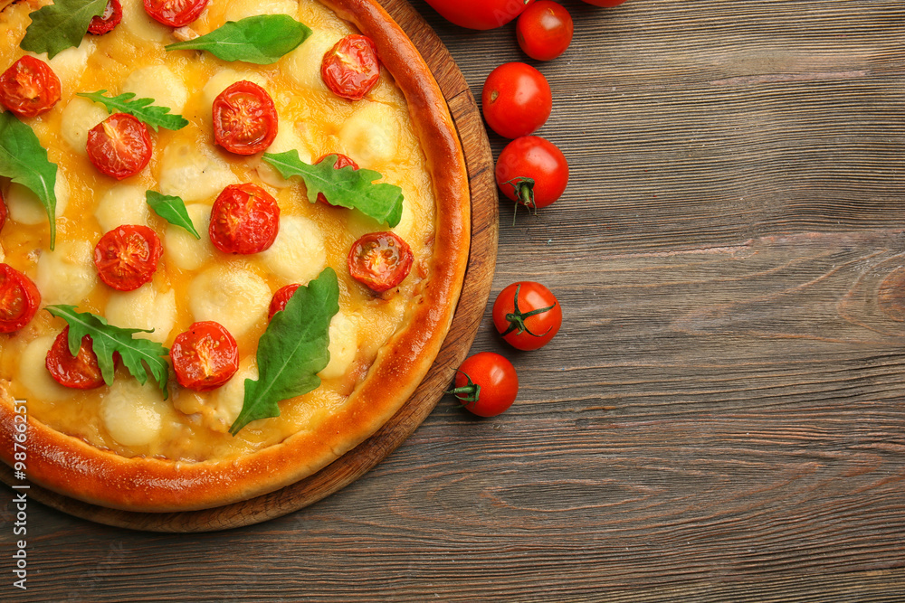 Pizza Margherita with arugula, tomatoes   wooden table
