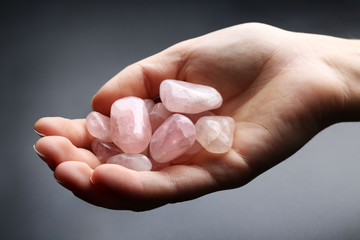 Wall Mural - Woman holding semiprecious stones in her hand on dark grey background