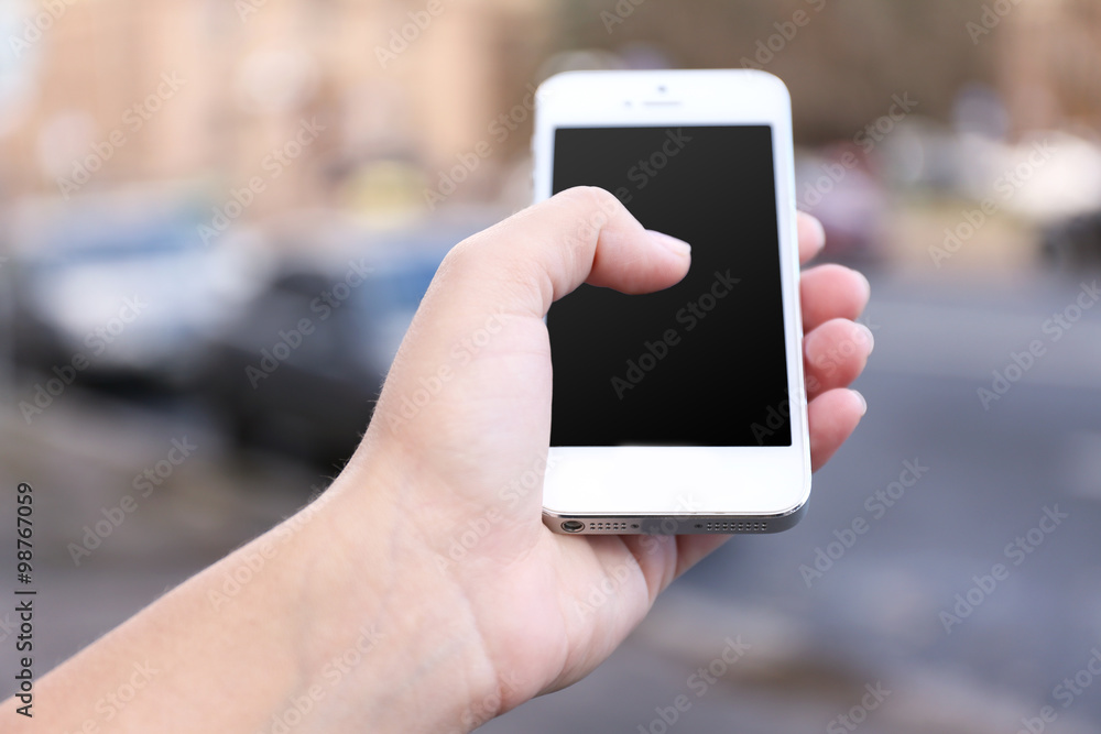 Woman holding smartphone outside