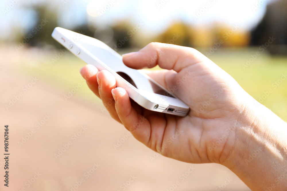 Woman holding smartphone outside