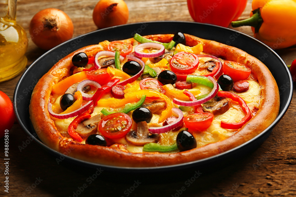 Delicious pizza with vegetables, on wooden table, close-up