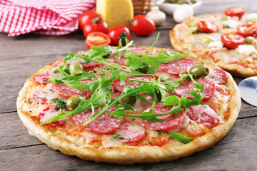 Poster - Delicious tasty pizzas with ingredients on table, closeup