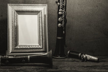 Still Life Of Picture Frame On Wooden Table With Clarinet