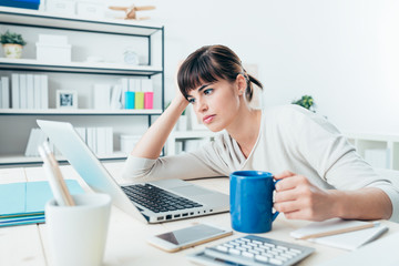 Tired woman at office desk