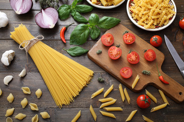 vista dall'alto Pasta grezza con basilico e pomodoro su sfondo legno rustico