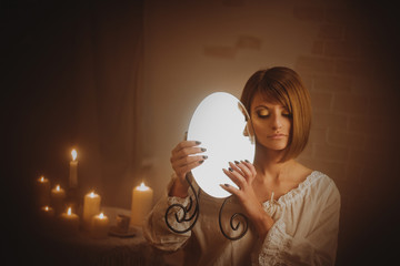 Divination woman with candle and mirror