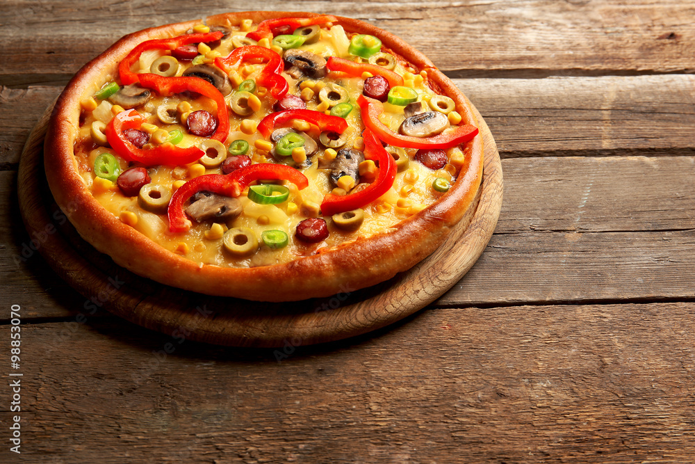 Delicious pizza on wooden background