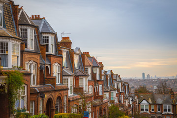 Wall Mural - Traditional British brick houses on a cloudy morning with east London at background. Panoramic shot from Muswell Hill, London, UK