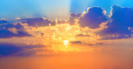 Beautiful sunset. Colorful sky with bright sun and cumulus clouds.