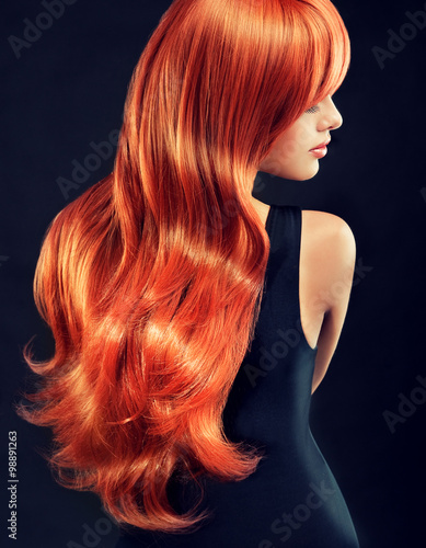 Plakat Piękna modelowa dziewczyna z długim czerwonym kędzierzawym włosy. Fryzura i kosmetyki