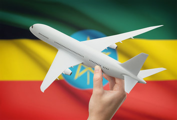 Wall Mural - Airplane in hand with flag on background - Ethiopia