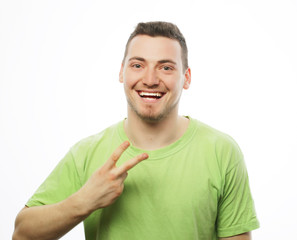 Wall Mural - young casual man showing the victory gesture