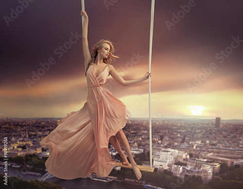 Nowoczesny obraz na płótnie Adorable woman swinging above the city