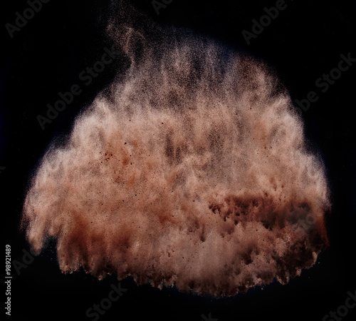 Brown powder  tornado over dark background