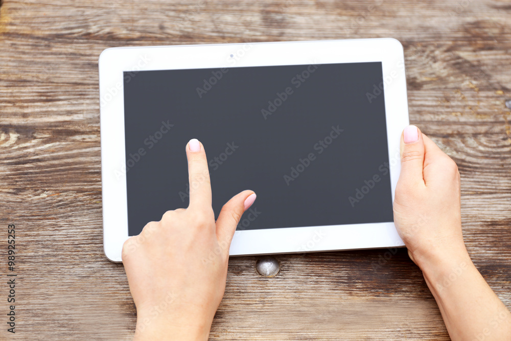 Woman working with tablet on wooden table