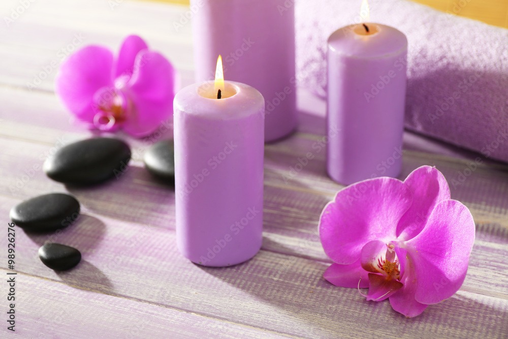 Spa set and candles on wooden background