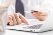 © Nonwarit - Man holding credit card in hand and entering security code using