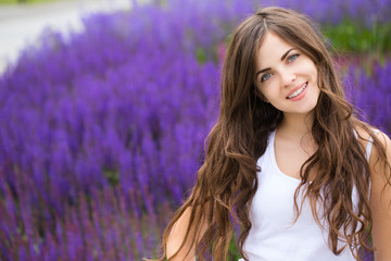 Wall Mural - Portrait of cute smiling woman in a park.