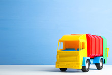 Bright Toy Garbage Truck From Plastic On Wooden Table On Blue Background