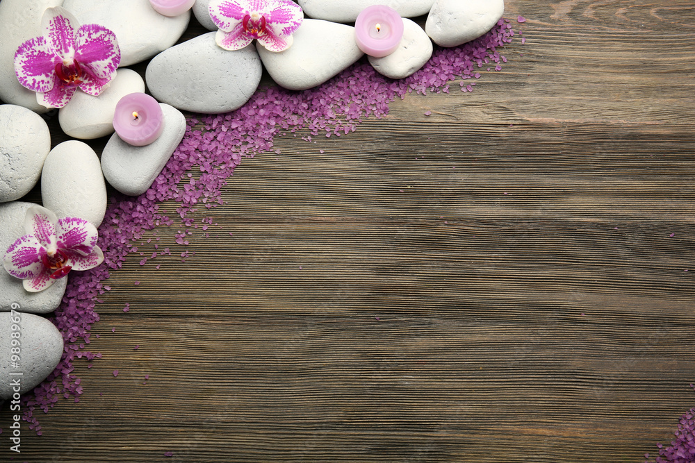 Spa stones and orchid on wooden background