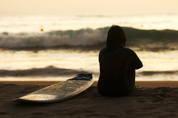 surfer woman silhouette  in the beach shore at sunset