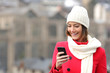 Girl texting in a mobile phone in winter