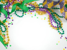 Mardi Gras Image Of Harlequin Mask, Beads, Ribbon And Confetti In Gold, Green And Purple