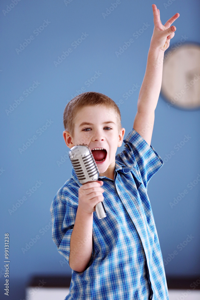 Little boy singing into the microphone at home