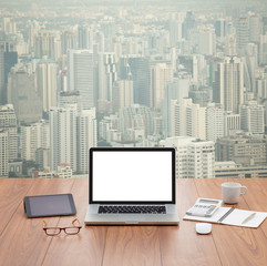 blank screen laptop computer with aerial view of cityscape backg