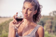 pretty girl looking glass of wine before drinking vintage